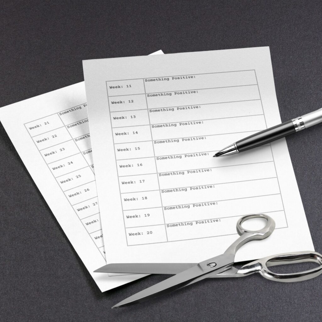A photo showing the free printable year of reflections worksheet with a pen and scissors