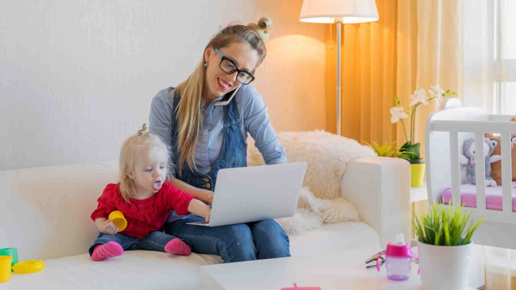 A mum and child sat looking a a laptop