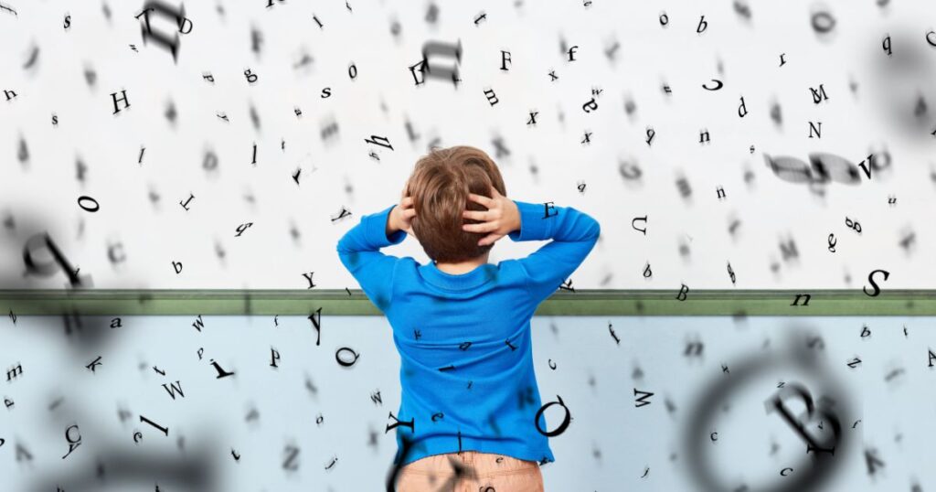 a young boy standing with lots of letters floating around