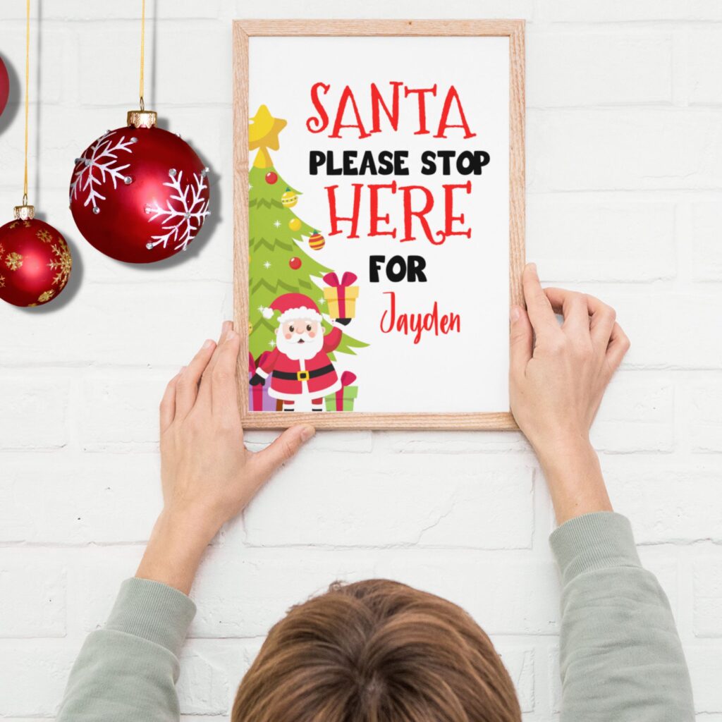 A lady putting up the Santa stop here sign