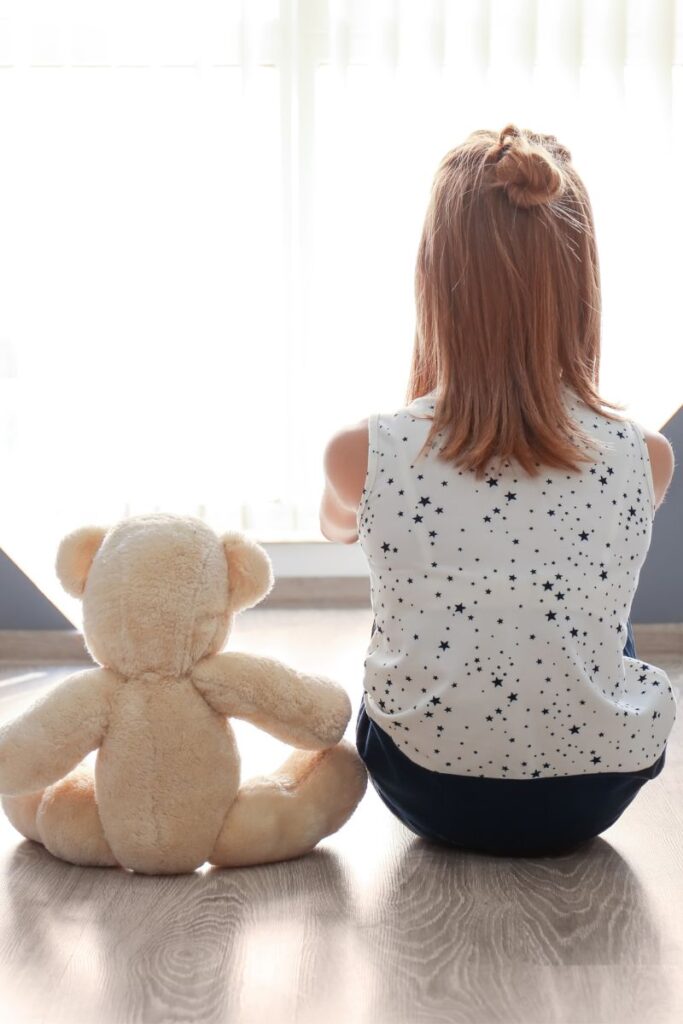 girl and teddy - Empowering Expression: Supporting Children with Selective Mutism blog post