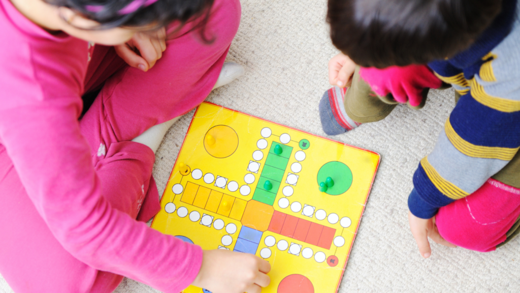 TWO CHILDREN PLAYING A BOARD GAME